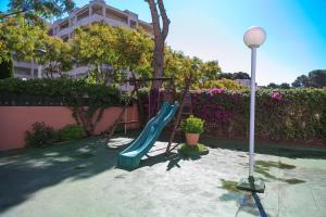 un parque infantil con un tobogán en un patio en UHC Buigas Luz Apartments, en Salou