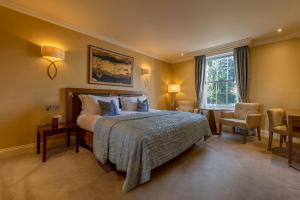 una camera con un letto e una sedia e una finestra di St Michael's Manor Hotel - St Albans a Saint Albans