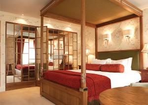 una camera da letto con un grande letto con una coperta rossa di St Michael's Manor Hotel - St Albans a Saint Albans