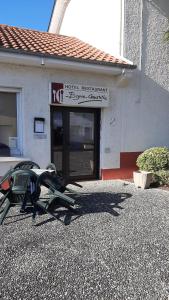 a hotel restaurant with a bench and a building at Beyrie Coustille in Uzein