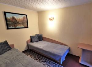 a room with two beds and a picture on the wall at Apartamentai Vasara in Juodkrantė