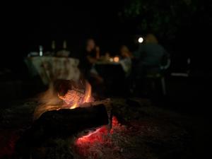 eine Feuerstelle im Dunkeln mit Menschen im Hintergrund in der Unterkunft Nature Guesthouse in Varshets