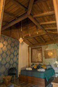 Riva del Sol Beach Resort في سانتا كاترينا ديلو يونو: غرفة نوم بسرير ازرق وسقف خشبي
