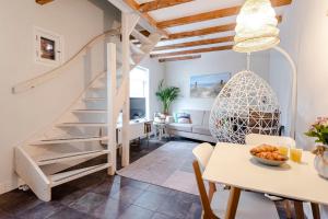 a staircase in a living room with a table and chairs at Kusthuiskatwijk in Katwijk aan Zee