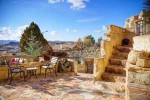 a stone patio with chairs and a table and stairs at 4 Oda Cave House - Special Class in Ürgüp