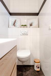 La salle de bains blanche est pourvue de toilettes et d'un lavabo. dans l'établissement Kusthuiskatwijk, à Katwijk aan Zee