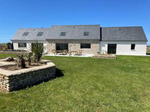 a house with a stone wall and a yard at TY MENEZ HEOL - Magnifique villa avec piscine in Ploudalmézeau