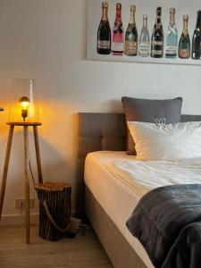 sypialnia z łóżkiem z butelkami na ścianie w obiekcie Maxi w mieście Westerland