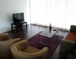 sala de estar con 2 sillas, mesa y TV en The Kapitani Residence, en Nicosia