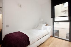 a bedroom with a white bed and a window at AB Gracia Sant Salvador in Barcelona