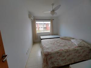 Habitación pequeña con cama y ventana en Joia da Praia, en Ilhéus