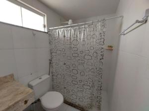 y baño con cortina de ducha y aseo. en Joia da Praia, en Ilhéus