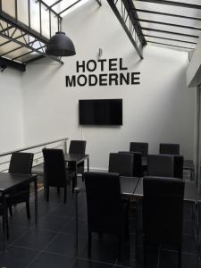 uma sala de reuniões com mesas e cadeiras e um sinal molecular de hotel em Hôtel Moderne em Maisons-Alfort