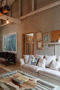 una sala de estar con 2 sofás blancos y una mesa. en Atlantic-Square Guesthouse en Swakopmund