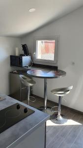 una cucina con tavolo e sgabelli in una stanza di Studio au centre du triangle Reims-Epernay-Chalons 