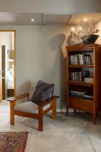 uma sala de estar com uma cadeira e uma estante de livros em Atlantic-Square Guesthouse em Swakopmund