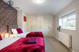 a bedroom with two beds and a window at Dwellers Delight Living Ltd 2 Bed House with Wi-Fi in Loughton, Essex in Loughton