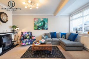 a living room with a couch and a table at Dwellers Delight Living Ltd 2 Bed House with Wi-Fi in Loughton, Essex in Loughton