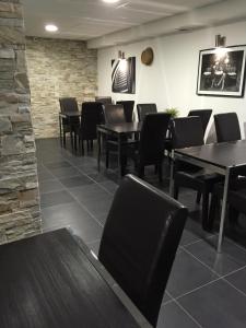 a dining room with black tables and chairs at Hôtel Moderne in Maisons-Alfort