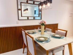 comedor con mesa con sillas y espejo en LOCAR-IN GRAMADO - Apartamento Residencial Haus, en Gramado