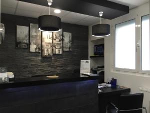 an office with a black counter and two pendant lights at Hôtel Moderne in Maisons-Alfort
