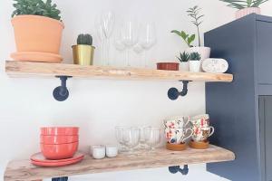 a wooden shelf with glasses and plants on it at Sunnyside at Scurlage Farm in Swansea