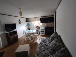 sala de estar con cama y cocina con mesa en Blanco en Mendoza