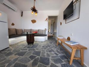 a living room with a couch and a tv at Janakos Luxury Apartment in Glinado Naxos