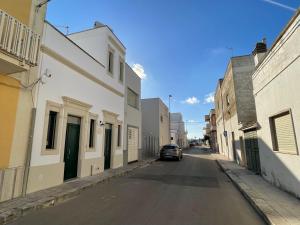 una calle vacía con un coche aparcado en el medio en La Casa di Rocco e Maria 1947, en Porto Cesareo