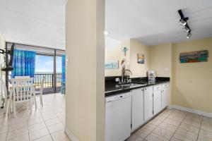 a kitchen with white cabinets and a view of the ocean at Laguna Reef #410 - BraveWave in Rockport