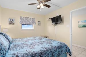 a bedroom with a bed and a flat screen tv at Laguna Reef #410 - BraveWave in Rockport +30 photos