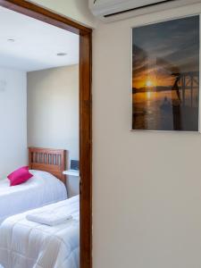 1 dormitorio con 2 camas y una foto en la pared en Casa Olivia en Ushuaia