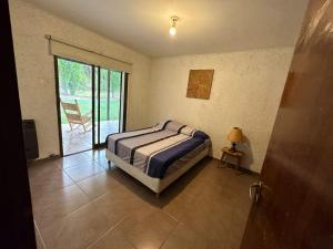 1 dormitorio con 1 cama y puerta corredera de cristal en Casa Víctor en Luján de Cuyo