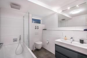 a white bathroom with a sink and a toilet at In Bayern in Warngau