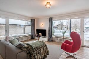 a living room with a couch and a red chair at In Bayern in Warngau