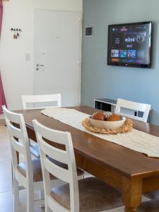 una mesa de comedor con sillas blancas y un plato de comida en Casa Olivia en Ushuaia