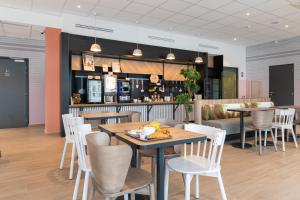 ViriatにあるB&B HOTELS Bourg-en-Bresse Viriatのテーブルと椅子のあるレストラン、バー
