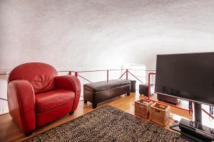 sala de estar con silla roja y TV de pantalla plana en Central Festival Apartment by Wonderful Italy en Sanremo