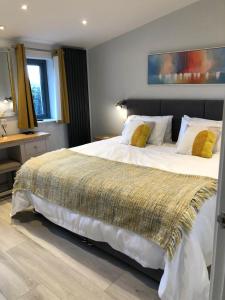 1 dormitorio con 1 cama blanca grande con almohadas amarillas en Thistledown Lodge! 5 minutes from beach! Free cancellation!, en Haverfordwest