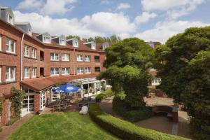 a large brick building with a garden in front of it at GHOTEL hotel & living Kiel in Kiel