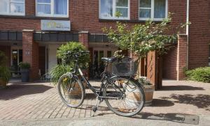 una bicicleta estacionada frente a un edificio de ladrillo en GHOTEL hotel & living Kiel en Kiel