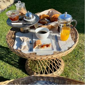 einen Tisch mit einem Tablett mit Speisen, Kaffee und Brot in der Unterkunft Villa Amahe - Chambres d'hôtes au coeur de Piriac sur Mer in Piriac-sur-Mer