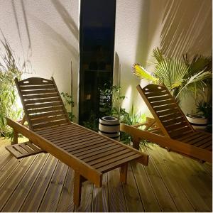 zwei Holzstühle mit Pflanzen auf einer Terrasse in der Unterkunft Villa Amahe - Chambres d'hôtes au coeur de Piriac sur Mer in Piriac-sur-Mer