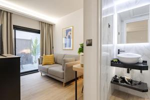 a bathroom with a couch and a sink in a room at Feelathome Ventas Suites in Madrid