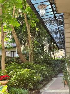 a walkway in a garden with flowers and trees at Casa Pagano Un pezzo di cielo su Milano in Milan