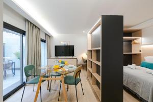 Zimmer mit einem Tisch, Stühlen und einem Bett in der Unterkunft Feelathome Ventas Suites in Madrid