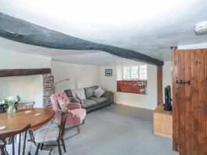 ein Wohnzimmer mit einem Sofa und einem Tisch in der Unterkunft Jean's Cottage in Exeter