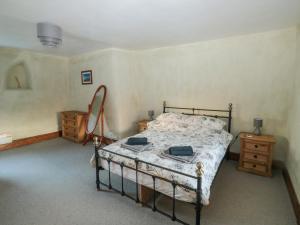 a bedroom with a bed and two dressers at Jean's Cottage in Exeter