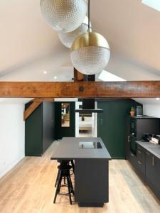 a kitchen with green walls and a table and two lights at Suite Théodore - 2 pers in Charleville-Mézières
