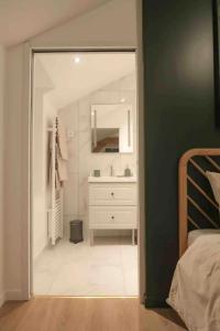 een badkamer met een witte wastafel en een spiegel bij Suite Théodore - 2 pers in Charleville-Mézières